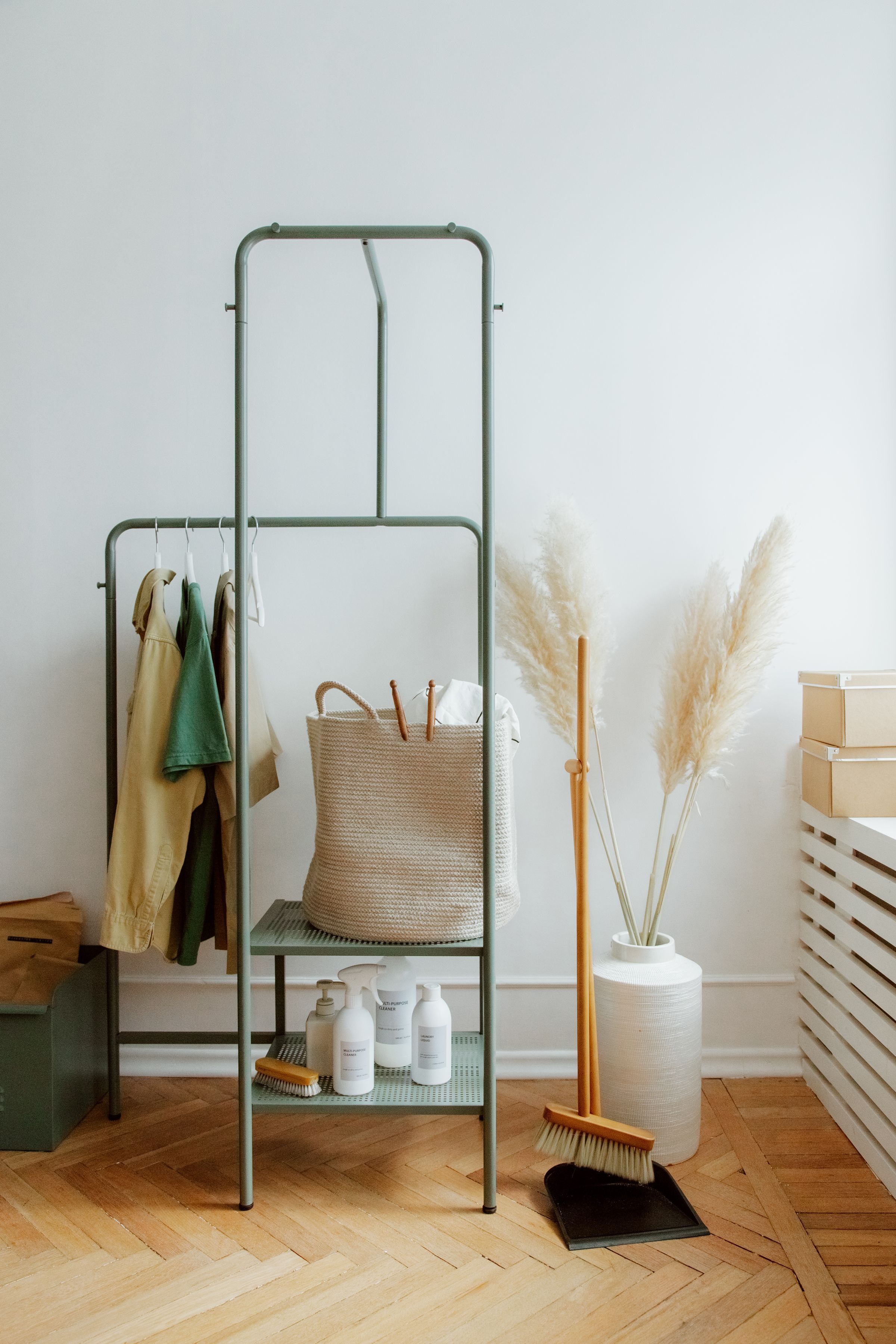 Cleaning products and a brush on a shelf beside a broom